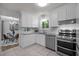 Well-lit kitchen with white cabinets, granite countertops, and stainless steel appliances at 568 Piney Mountain Rd, Chapel Hill, NC 27514