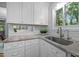 Close-up of a kitchen featuring granite countertops, subway tile backsplash, and a stainless steel sink at 568 Piney Mountain Rd, Chapel Hill, NC 27514