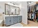 Bathroom with a dual sink vanity, large mirror, and a walk-in closet at 5701 Hadrian Dr Dr, Durham, NC 27703