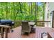Outdoor deck with a barbecue grill, dining table, and natural views at 5701 Hadrian Dr Dr, Durham, NC 27703