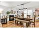 Elegant dining room featuring a cozy fireplace, ample natural light, and a stylish dining set with bench seating at 5701 Hadrian Dr Dr, Durham, NC 27703