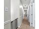 Upstairs hallway with neutral carpet, fresh paint and a baby gate at 5701 Hadrian Dr Dr, Durham, NC 27703