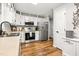 Well-lit kitchen featuring stainless steel appliances, stylish cabinets, and hardwood floors at 5701 Hadrian Dr Dr, Durham, NC 27703