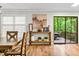 Living room with access to a deck features hardwood floors, natural light, and tasteful decor on a console table at 5701 Hadrian Dr Dr, Durham, NC 27703