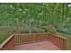 Scenic backyard view with a wooden deck and garden shed, surrounded by tall trees and lush greenery at 5825 Scalybark Rd, Durham, NC 27712