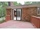 Outdoor patio overlooking a backyard, with a brick exterior and sliding glass door at 5825 Scalybark Rd, Durham, NC 27712