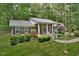 Traditional brick home with manicured landscaping, inviting front porch and lush green surroundings at 5825 Scalybark Rd, Durham, NC 27712