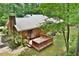 Brick house with a cozy deck, surrounded by beautiful trees and lush landscaping creating a serene atmosphere at 5825 Scalybark Rd, Durham, NC 27712