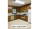 Spacious kitchen features wooden cabinets, a window over the sink, and vintage appliances at 5825 Scalybark Rd, Durham, NC 27712