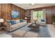 Stylishly staged living room with modern furniture, wood paneled walls and sliding glass doors at 5825 Scalybark Rd, Durham, NC 27712