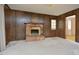 Living room with wood-paneled walls, brick fireplace, access to outdoor deck and an adjoining room at 5825 Scalybark Rd, Durham, NC 27712