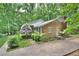 Brick home featuring mature trees, a driveway, and landscaping along the side of the house at 5825 Scalybark Rd, Durham, NC 27712