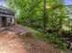 Backyard fire pit area surrounded by mature trees and landscaping, perfect for outdoor gatherings at 6125 Bellow St, Raleigh, NC 27609