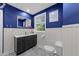 Bright bathroom featuring blue walls, white wainscoting, and a modern vanity with marble countertop at 6125 Bellow St, Raleigh, NC 27609