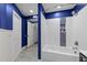 Bathroom with white subway tile surround bathtub, blue accent niche, and coordinating blue walls at 6125 Bellow St, Raleigh, NC 27609