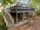 Exterior view of a home showcasing a large deck and a staircase leading to the backyard at 6125 Bellow St, Raleigh, NC 27609