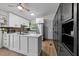 Modern kitchen features white cabinets, stainless steel appliances, and a stylish kitchen island with a sink and black faucet at 6125 Bellow St, Raleigh, NC 27609