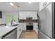 Bright kitchen boasts stainless steel appliances, white cabinets, light countertops and sleek black hardware at 6125 Bellow St, Raleigh, NC 27609