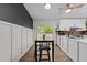 Modern kitchen with white cabinets, breakfast bar, and a sliding door to an outdoor patio at 6125 Bellow St, Raleigh, NC 27609