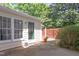 Exterior view of a private patio area leading to a fenced backyard, surrounded by lush landscaping at 6922 Saxby Ct, Raleigh, NC 27613