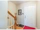 Bright foyer featuring hardwood floors, a white front door, and a staircase with wooden banister at 6922 Saxby Ct, Raleigh, NC 27613