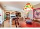 Open-concept living and dining area featuring hardwood floors, a fireplace, and stained-glass lighting fixture at 6922 Saxby Ct, Raleigh, NC 27613