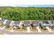 Aerial view showcases a neighborhood with well-maintained homes and lush greenery, surrounded by a dense forest at 745 Orange Oak Ln, Apex, NC 27523