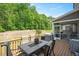 Spacious back deck featuring an outdoor dining table, chairs, and grill overlooking the green space at 745 Orange Oak Ln, Apex, NC 27523
