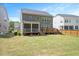 Exterior backyard view with deck and screened porch overlooking large, well-maintained lawn at 745 Orange Oak Ln, Apex, NC 27523