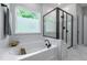 Bright bathroom featuring a garden tub, separate shower with glass enclosure and marble tiling at 745 Orange Oak Ln, Apex, NC 27523