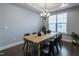 Modern dining room features a wooden table with black chairs, stylish chandelier, and lots of natural light at 745 Orange Oak Ln, Apex, NC 27523