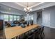 Modern dining room flows to living room and features a wooden table with black chairs and a stylish chandelier at 745 Orange Oak Ln, Apex, NC 27523