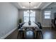 Modern dining room features a wooden table with black chairs, stylish chandelier, and lots of natural light at 745 Orange Oak Ln, Apex, NC 27523