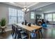 Modern dining room features a wooden table with black chairs, stylish chandelier, and lots of natural light at 745 Orange Oak Ln, Apex, NC 27523