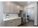 Close-up of the kitchen featuring gray cabinets, white countertops, and stainless steel refrigerator at 745 Orange Oak Ln, Apex, NC 27523
