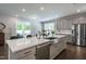 Bright kitchen features stainless appliances, gray cabinets, large island with sink, and access to an outdoor patio at 745 Orange Oak Ln, Apex, NC 27523