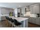 Modern kitchen with gray cabinets, stainless steel appliances, and island with bar stools at 745 Orange Oak Ln, Apex, NC 27523