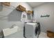 Convenient laundry room with appliances, utility sink, wire shelving and stylish decorations at 745 Orange Oak Ln, Apex, NC 27523