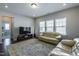 Comfortable living room featuring hardwood floors, a large couch, and natural light from three windows at 745 Orange Oak Ln, Apex, NC 27523