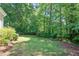 Picturesque backyard with mature trees offering privacy and a well-maintained lawn at 7716 Micklewaithe Ct, Wake Forest, NC 27587