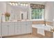 Bright bathroom with garden tub, window, dual vanity and ample cabinet space at 7716 Micklewaithe Ct, Wake Forest, NC 27587