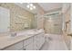 Bright bathroom featuring a double vanity sink and a shower over tub with glass doors at 7716 Micklewaithe Ct, Wake Forest, NC 27587