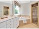Bright bathroom features a soaking tub, glass-enclosed shower, and vanity with plentiful storage at 7716 Micklewaithe Ct, Wake Forest, NC 27587