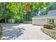 Long driveway leads to a two-car garage and a home with mature trees and landscaping at 7716 Micklewaithe Ct, Wake Forest, NC 27587