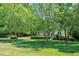 Home with mature trees, lush lawn and trimmed shrubs at 7716 Micklewaithe Ct, Wake Forest, NC 27587