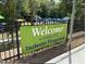Welcome sign to Holding Park Inclusive Playground, surrounded by a black fence and greenery at 7716 Micklewaithe Ct, Wake Forest, NC 27587
