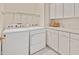 Well-organized laundry room with white cabinets, counter space, and modern appliances at 7716 Micklewaithe Ct, Wake Forest, NC 27587
