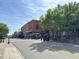 Street view of downtown with brick buildings, mature trees, and outdoor seating areas at 7716 Micklewaithe Ct, Wake Forest, NC 27587