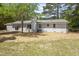 Backyard view showcasing the home's exterior and expansive yard with mature trees at 7824 Knightdale Blvd, Knightdale, NC 27545
