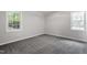 Carpeted bedroom with neutral paint and natural lighting from dual windows at 7824 Knightdale Blvd, Knightdale, NC 27545